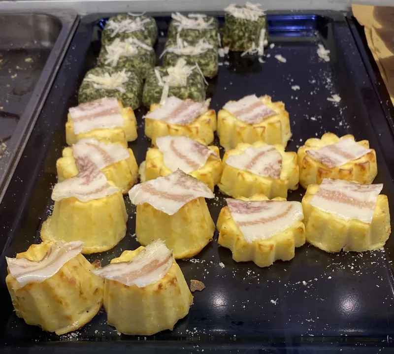 Sformatini di patate con pancetta e tortini di spinaci con scaglie di formaggio su una teglia